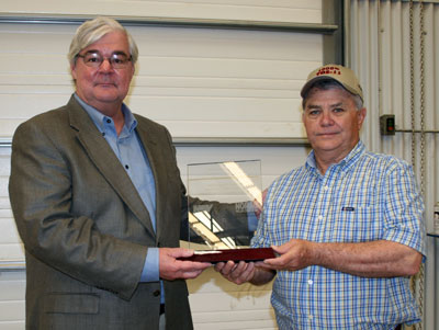 Pete Miller (left), NOV chairman, president and CEO, presents an award to Sam McCaskill, Nomac Drilling president, in recognition of Nomac’s receipt of NOV’s 1,000th TDS-11 top drive.