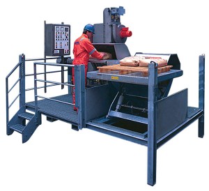 Figure 4: A sack-handling unit elevates sacks to the most ergonomic height. The operator slides the sack onto the roller table and pushes it into the machine, which automatically starts and performs the slitting, emptying and feeding sequence, including packing the emptied sack into the waste bag. Courtesy of National Oilwell Varco