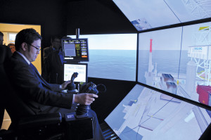 Daikichi Kukuta from Japan Radio Company attempts to safely land a container on a rig using the crane simulator at the MOSAIC II, where different simulators can be integrated with one another for a team-based training experience.