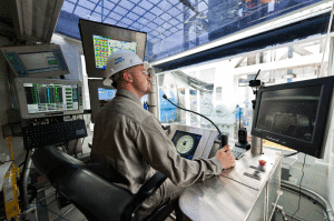 A driller sits inside the driller’s cabin on an advanced-technology rig working for Oxy. The company is currently looking at ROP optimization using an electronic control system to adjust weight on bit and rotary speed to continuously optimize drilling parameters.