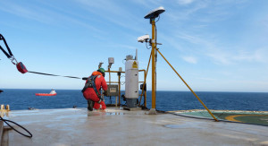A Fugro service engineer installs a real-time helideck and environmental monitoring system to aid operational planning and safety.