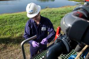 A Baker Hughes water treatment specialist captures a water sample from an H2prO treatment unit that converts produced water into a reusable resource for hydraulic fracturing. A typical hydraulic fracturing operation requires 2.5 million to 4 million gallons of water.