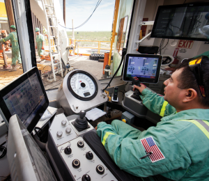 A driller controls the drilling process from his cabin on Precision Rig 575. Precision Drilling began its Target Zero program in 2000 to reinforce and improve policies and practices to meet the goal of zero injuries.